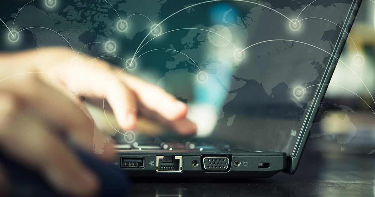 Manos escribiendo en un portátil con iconos de nube, representando la migración de una web